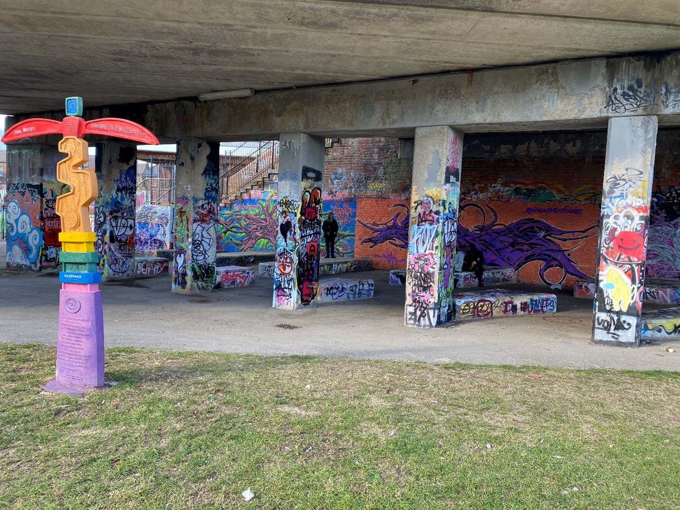 Underneath the bridge. Pillars and walls covered in graffiti 