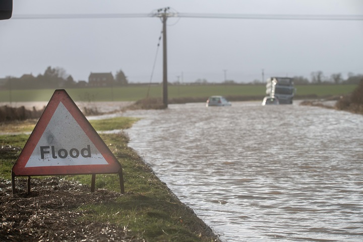 Flooded road with a flood warning sign