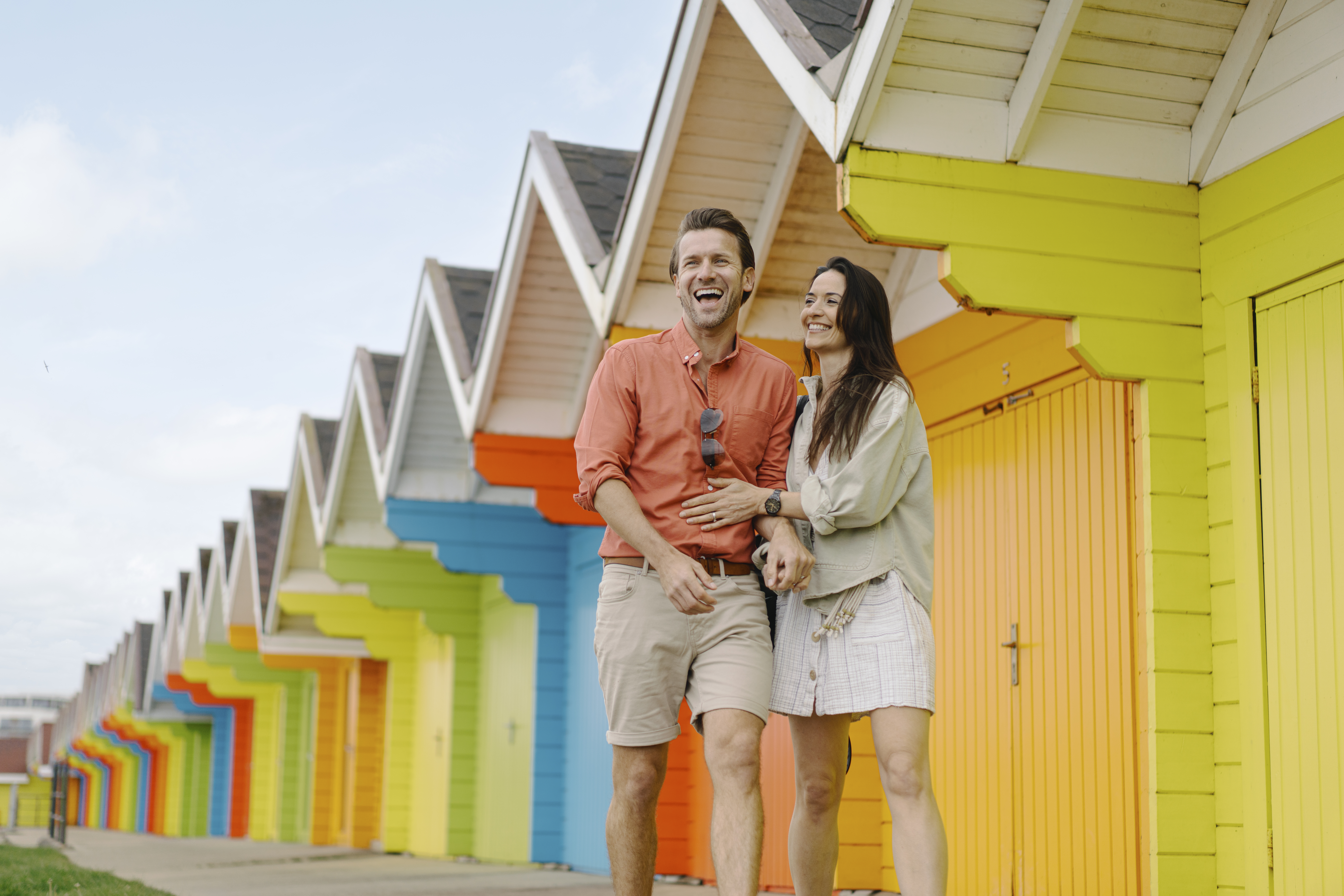 Two people in front of beach huts