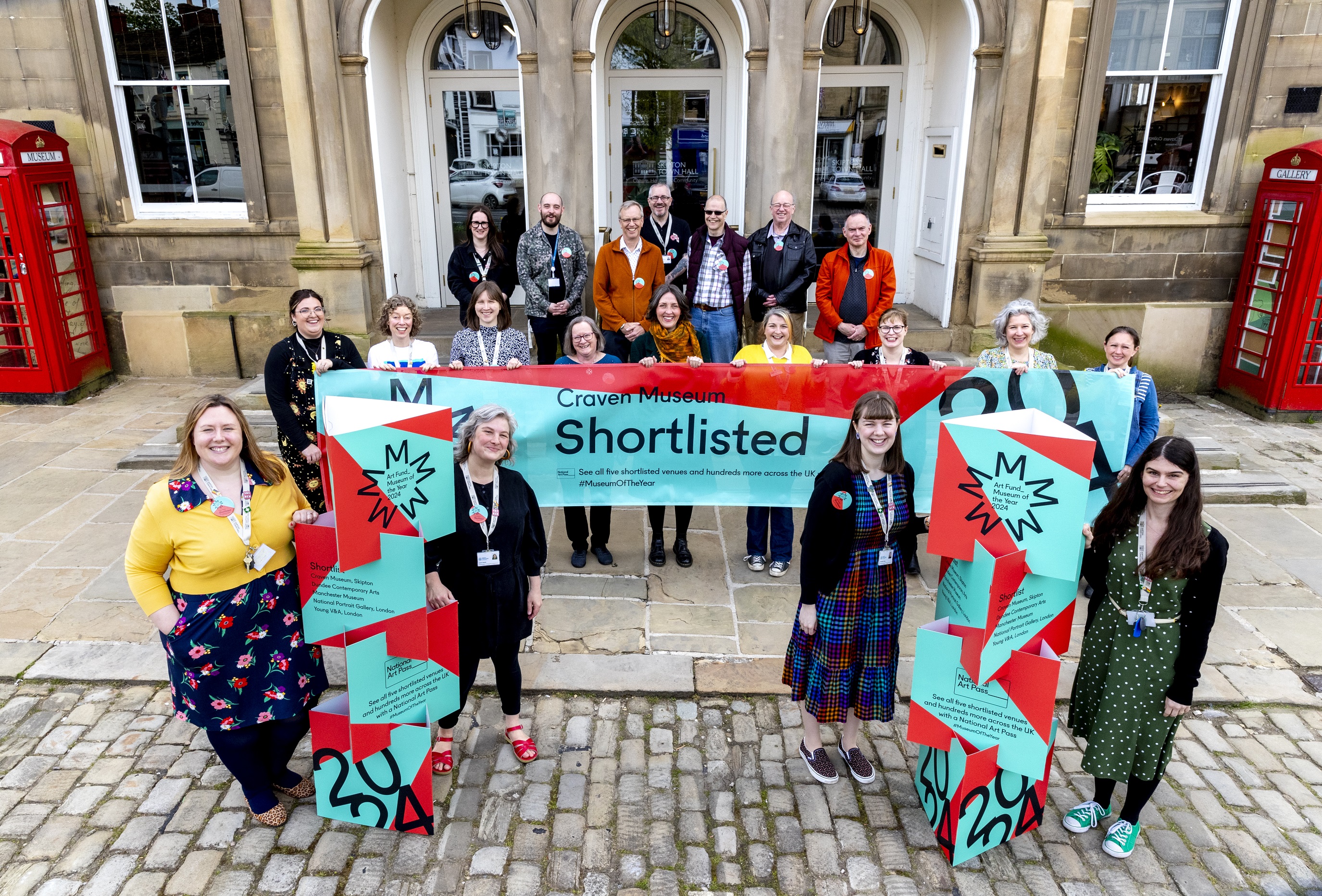 The Skipton Town Hall team, including staff and volunteers, celebrates Craven Museum's selection as a finalist for Art Fund’s Museum of the Year 2024. Photo credit: Stephen Garnett.