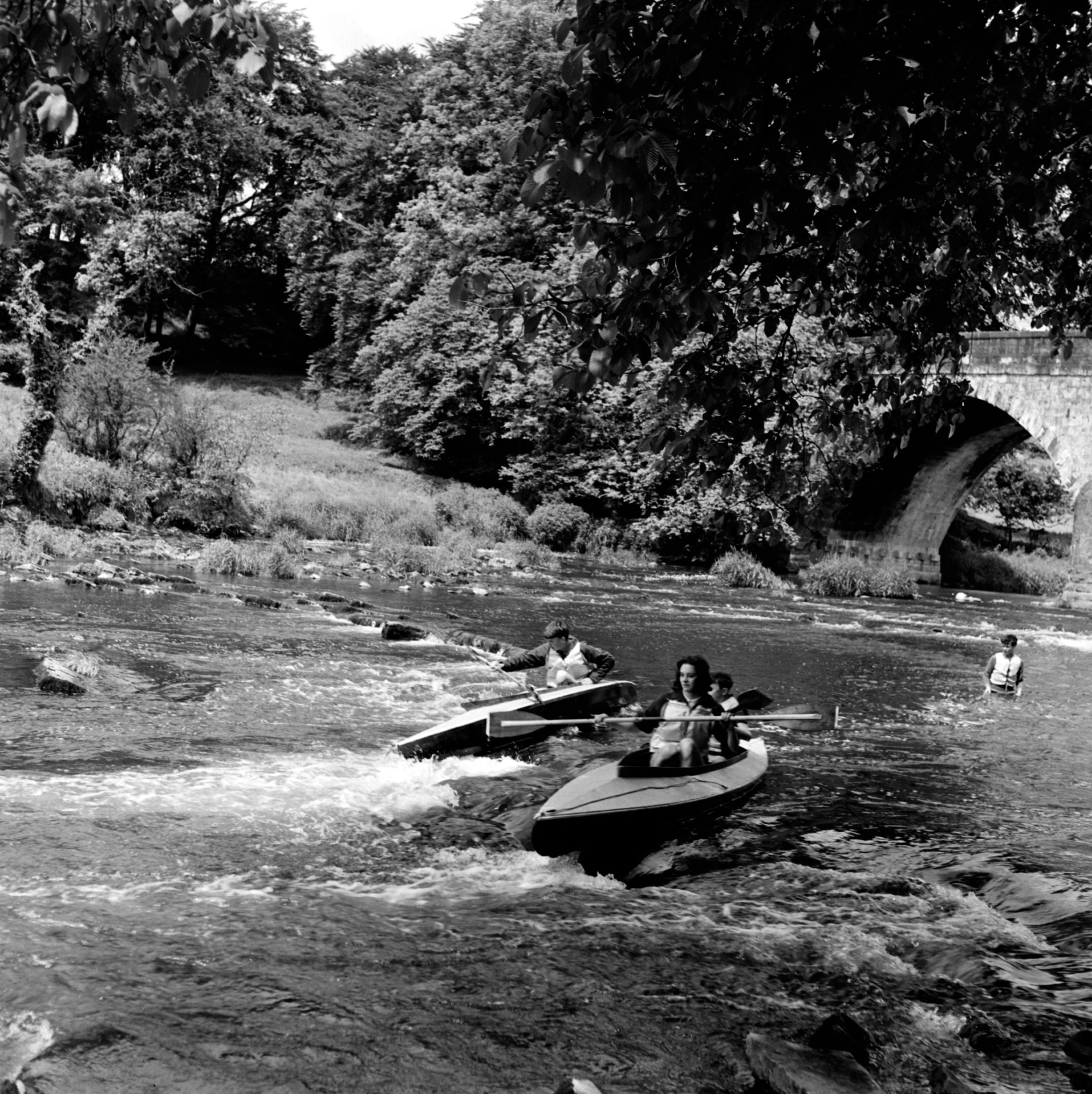 A group of canoeists enjoying the rapids of the River Ribble under Paythorne Bridge (no date). From the Bertram Unné photographic collection.