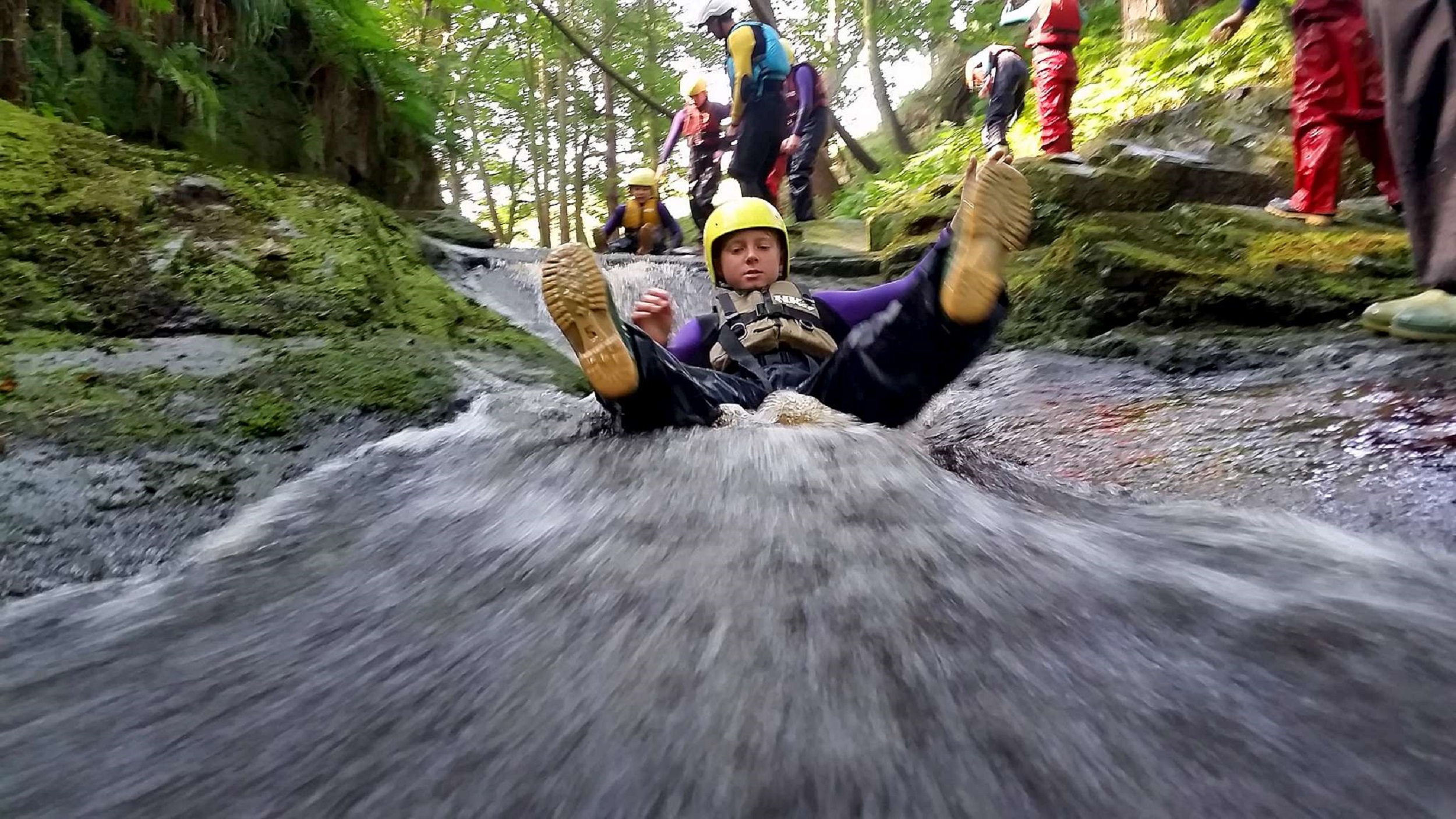 A person sliding along water as part of an Outdoor Learning exercise