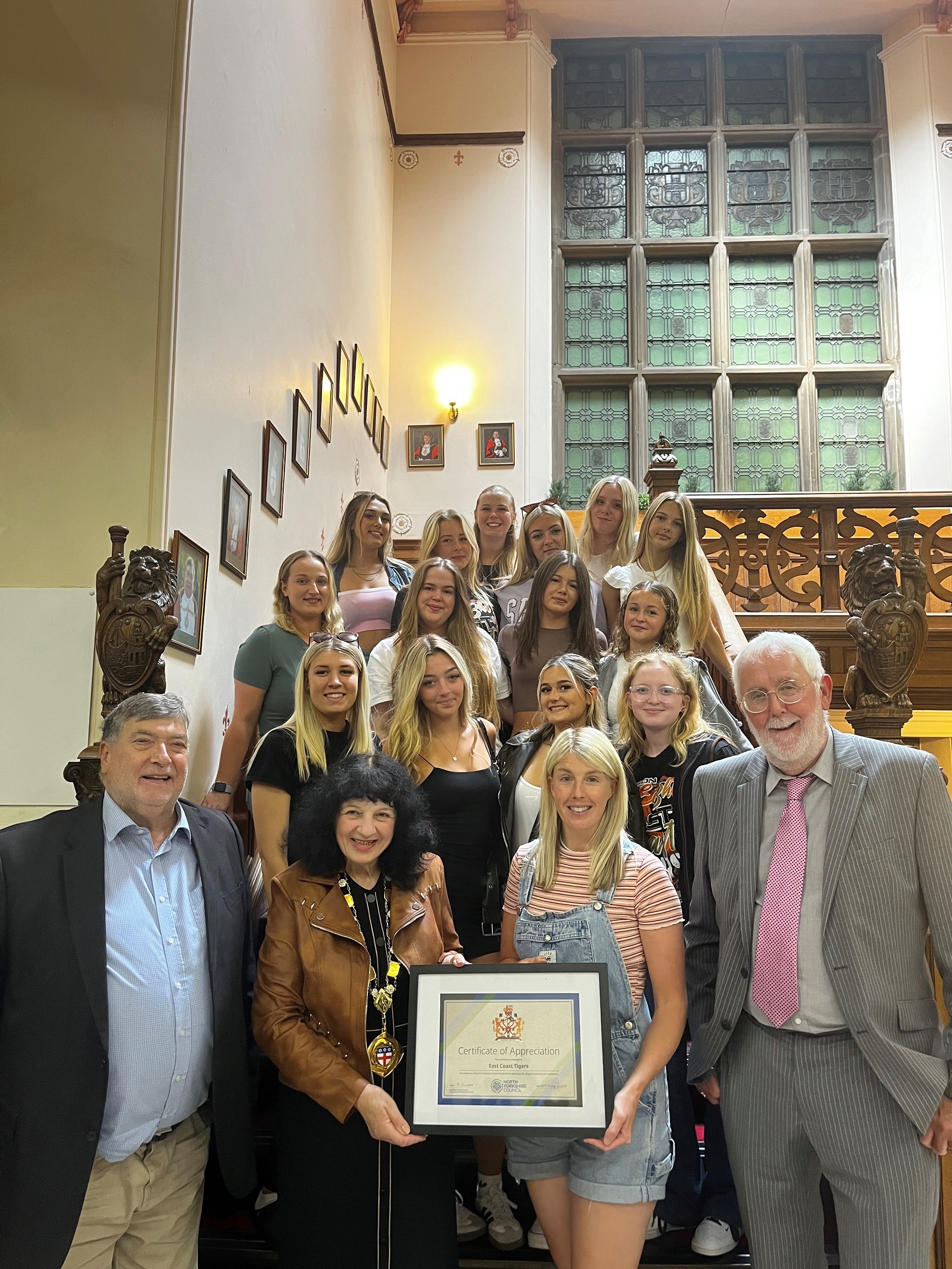  From left to right, Cllr Eric Broadbent, Cllr Roberta Swiers, lead team coach Jess Mortimer and Cllr Tony Randerson with cheerleading champions East Coast Tigers celebrating their remarkable achievements.   