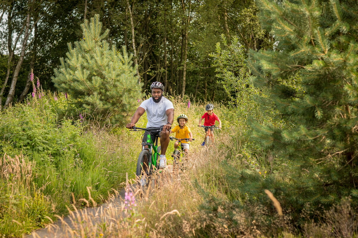 An adult and two children on bikes