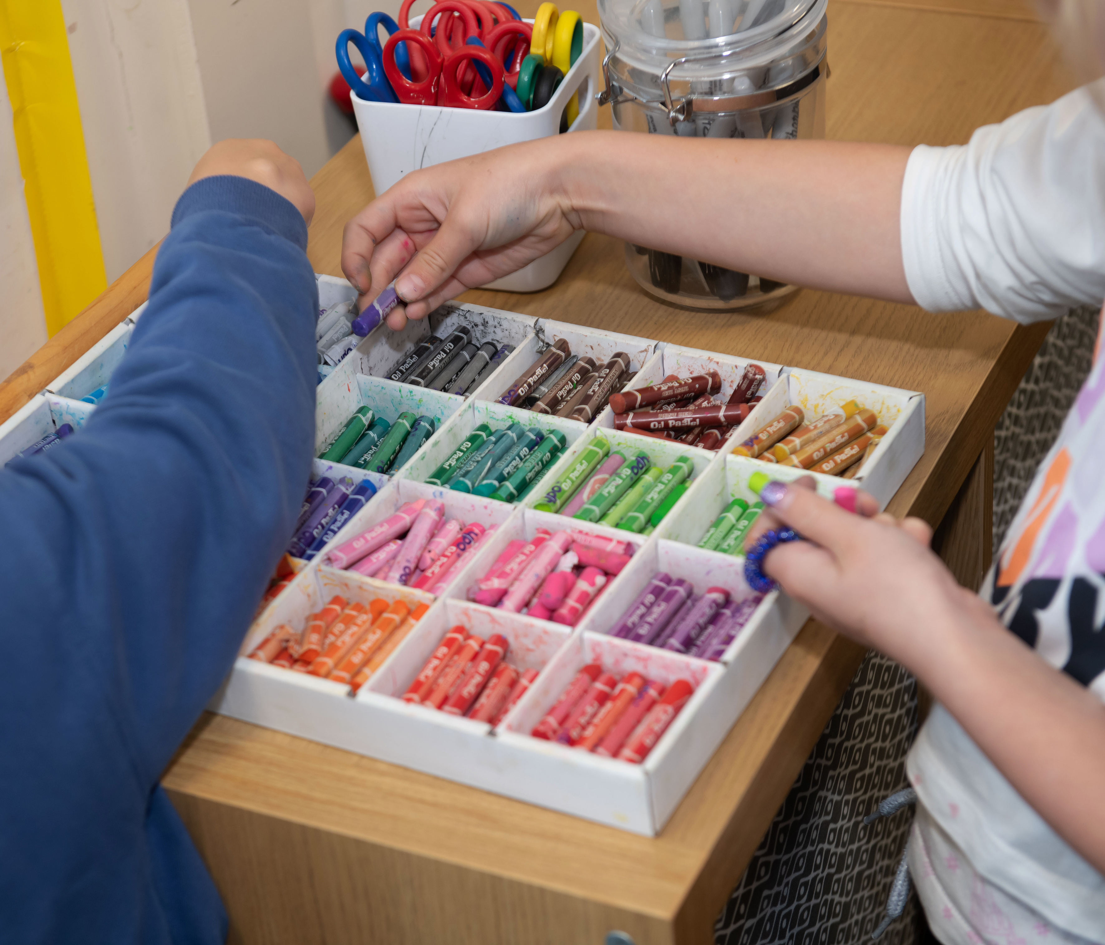 Two children sorting crayons