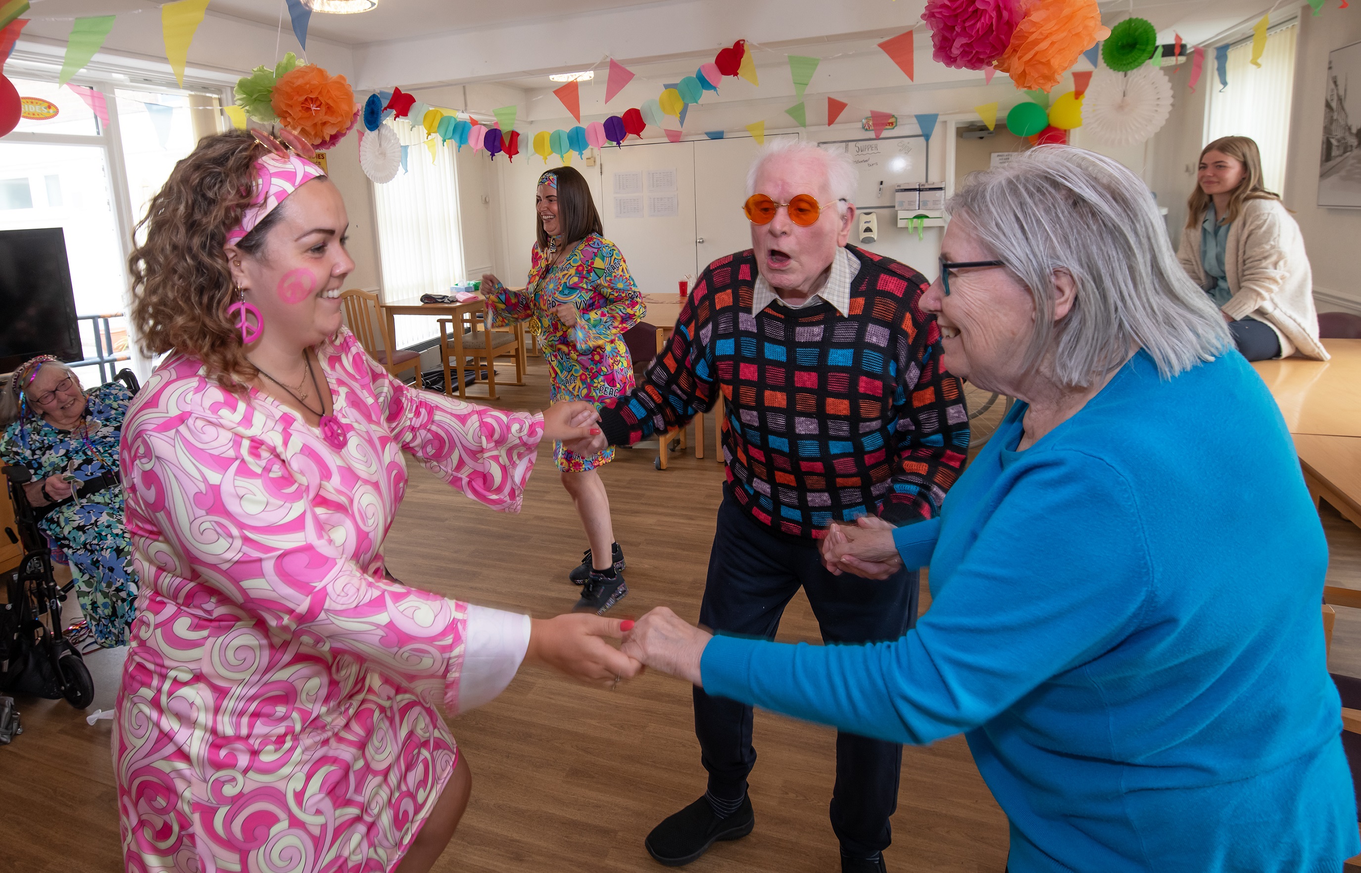 Three people dancing at a care home