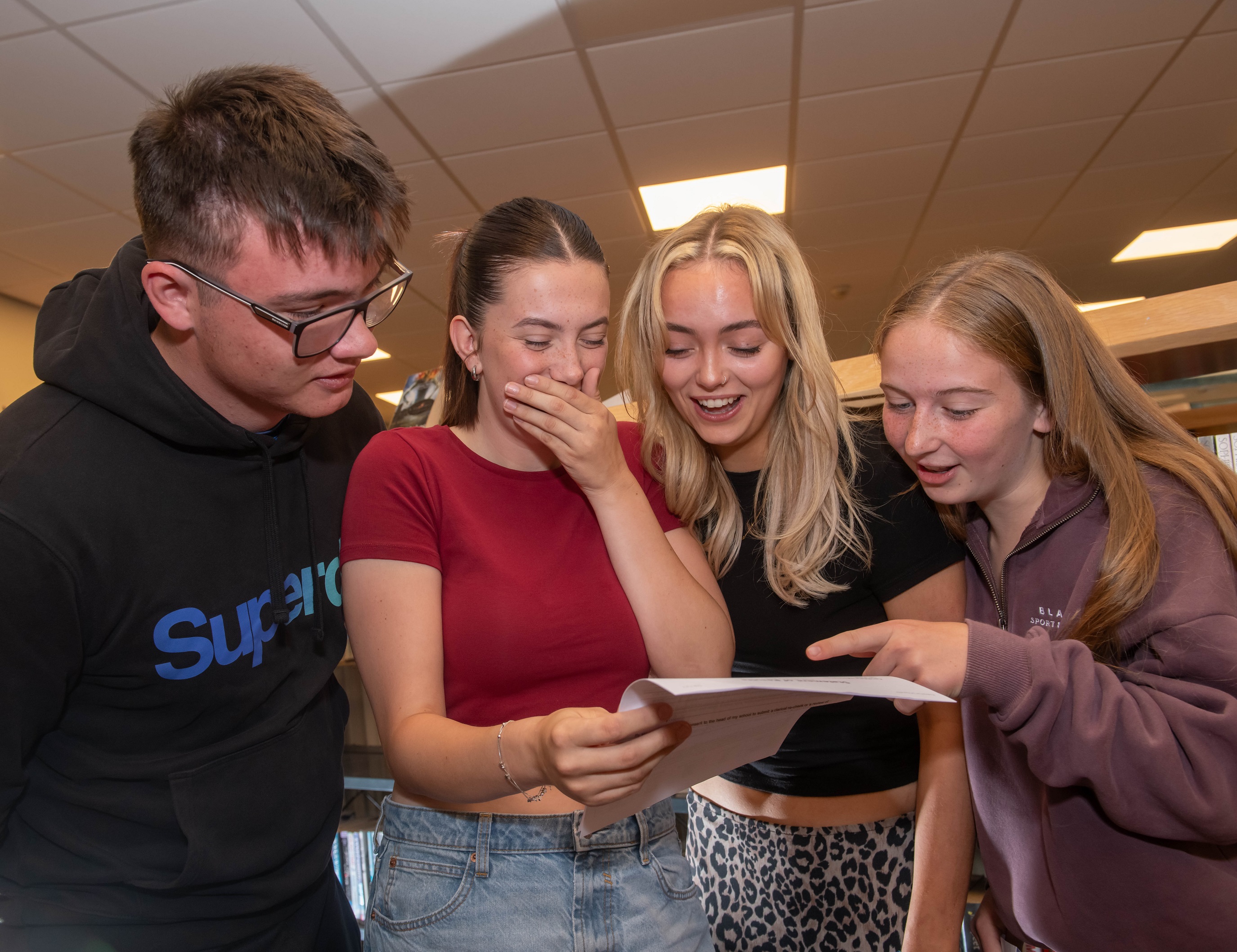 Four young people looking at their exam results