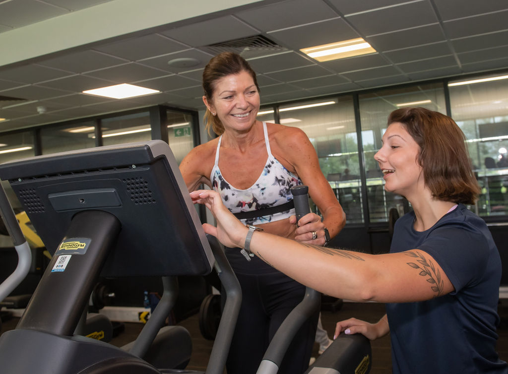 One of our Active North Yorkshire fitness instructors showing a customer how to use a treadmill.