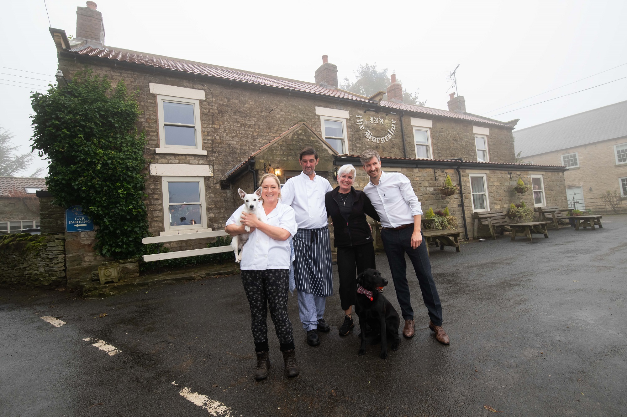 People outside the Horseshoe Inn. From left, chefs Michelle Fletcher and Paul Gaines, head of housekeeping, Gill Williams, general manager, Iain Yates, and dogs Monty and Blue