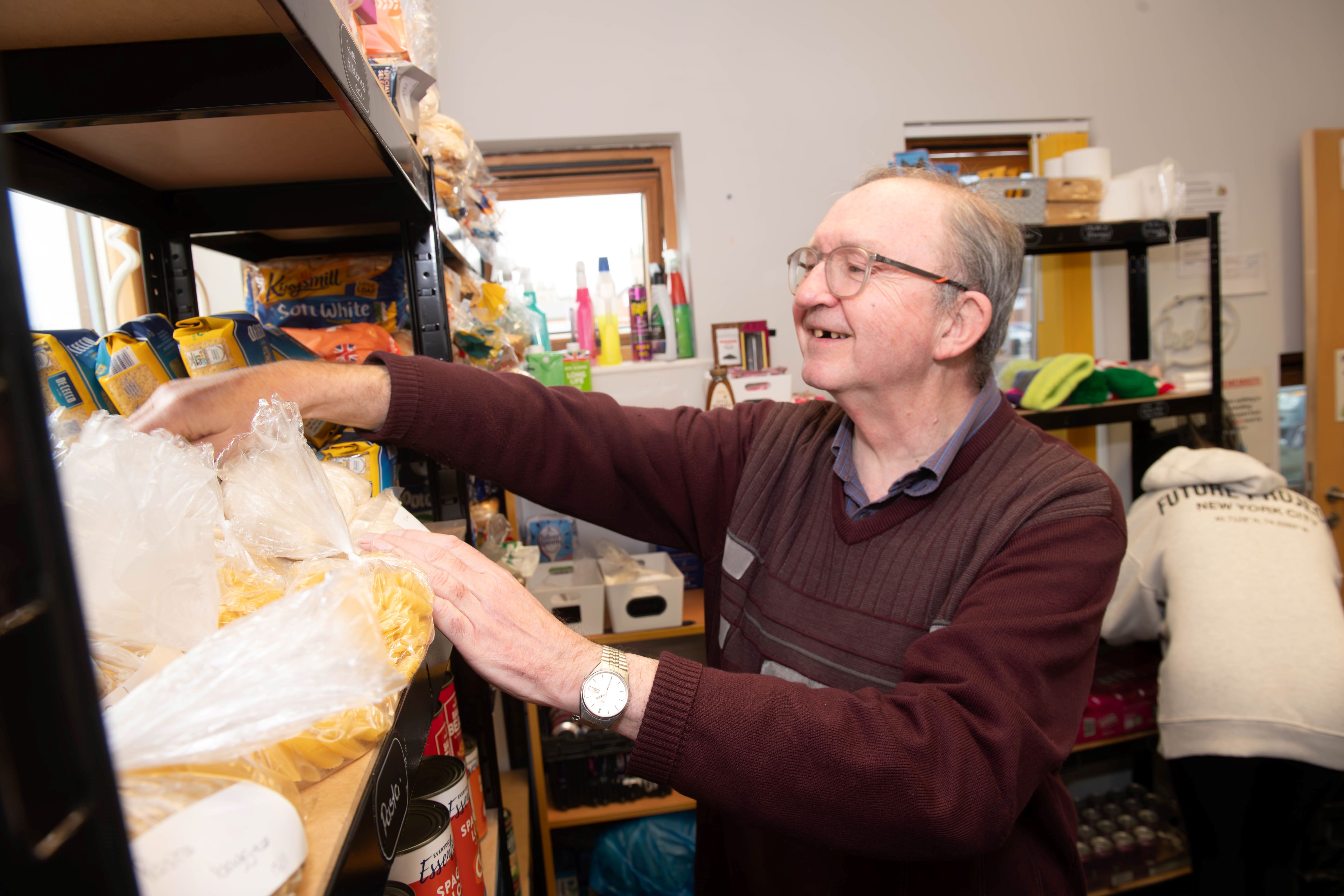 A person stocking a food bank shelf