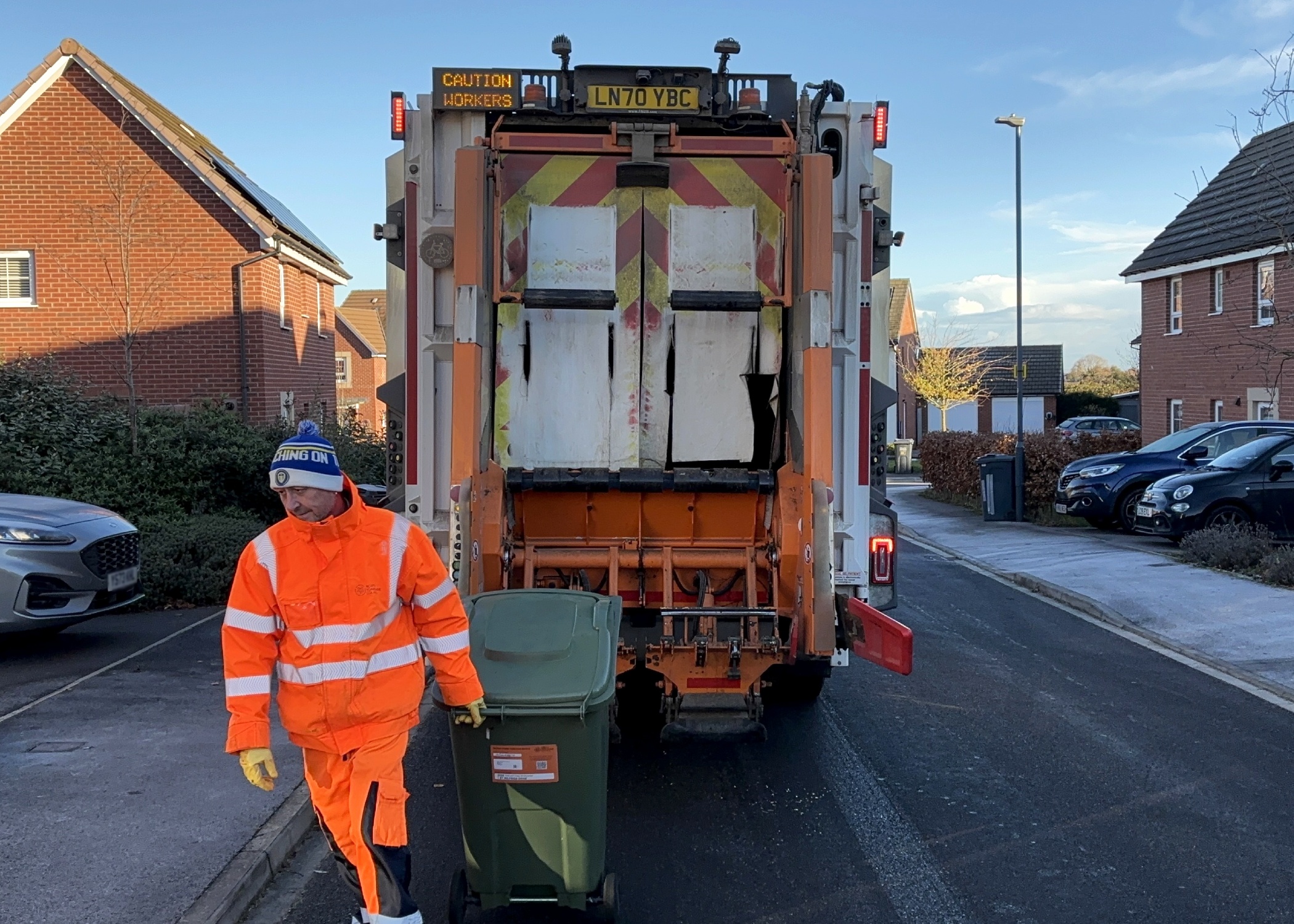 A man emptying a wheelie bin