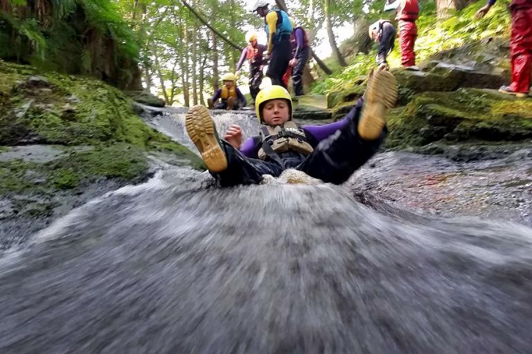 A person sliding along water as part of an Outdoor Learning exercise