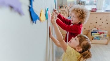 Children sticking animals to a wall