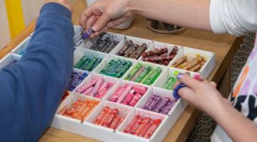 Two children sorting crayons