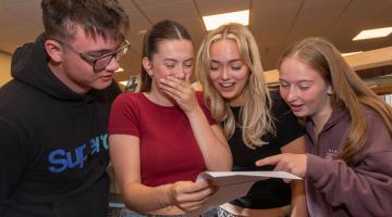 Four young people looking at their exam results