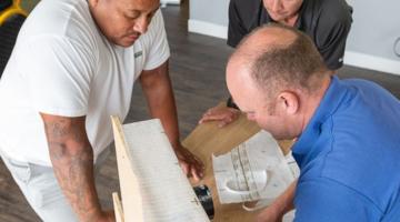 Three builders builders at a free class to train in energy efficiency techniques.