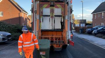 A binman collecting a green bin