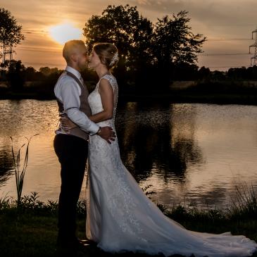 Bride and groom together in front of a sun set.