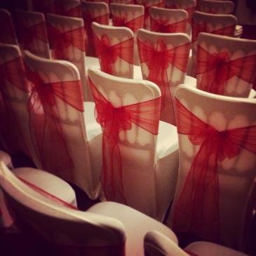 Rows of seats covered in colourful ribbons.