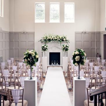 Chairs set up with flowers and aisle for wedding ceremony.